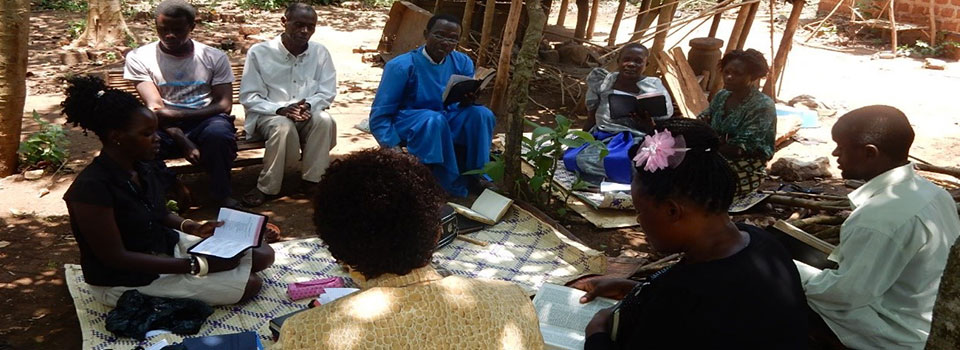 MIFA Staff praying with the family during their pastoral visit in Kyanpisi Sub-County, Mukono District.